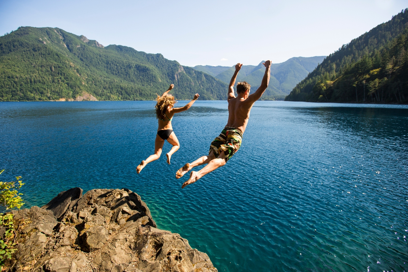 Couple jumping into the lake